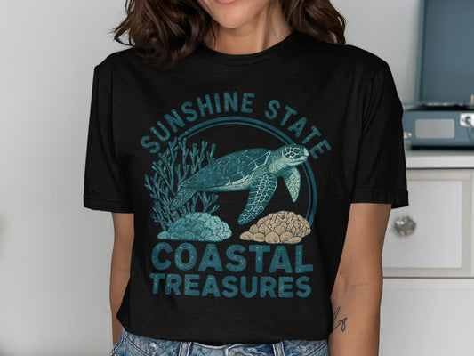 Sea turtle and coral graphic with "Sunshine State Coastal Treasures" text on a dark t-shirt.